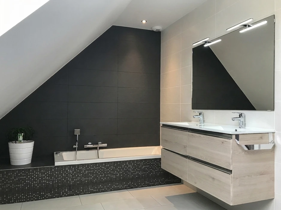 Salle de bain moderne sous combles avec baignoire encastrée sur tablier mosaïque noire