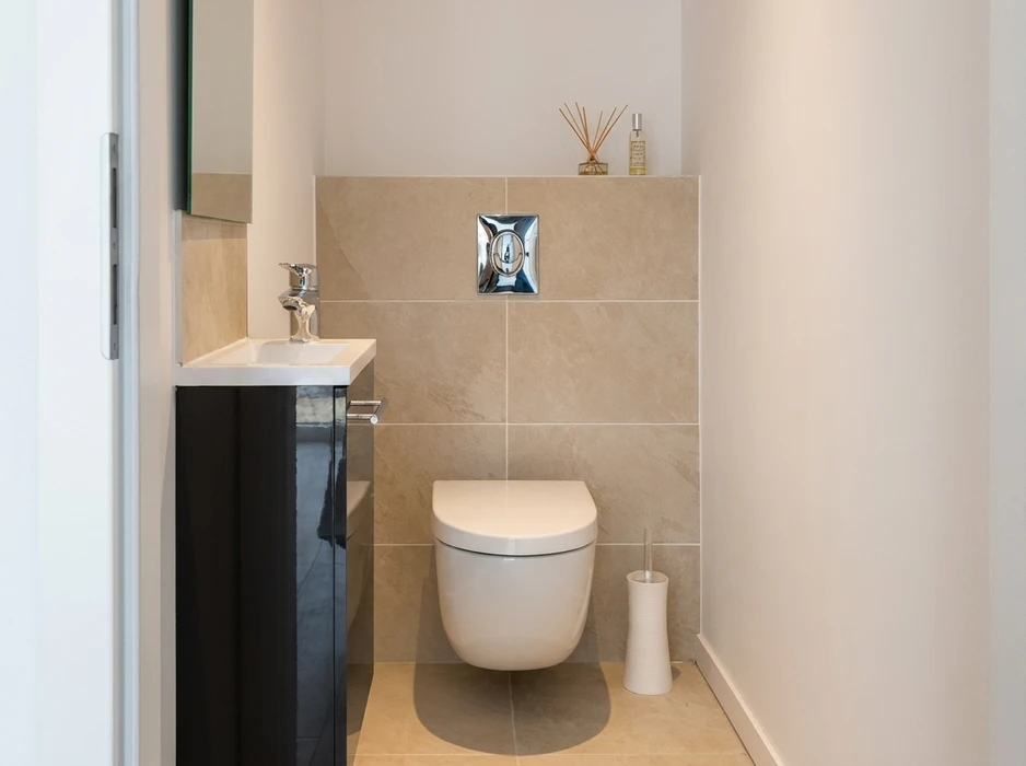 WC suspendu blanc dans une salle de bains compacte