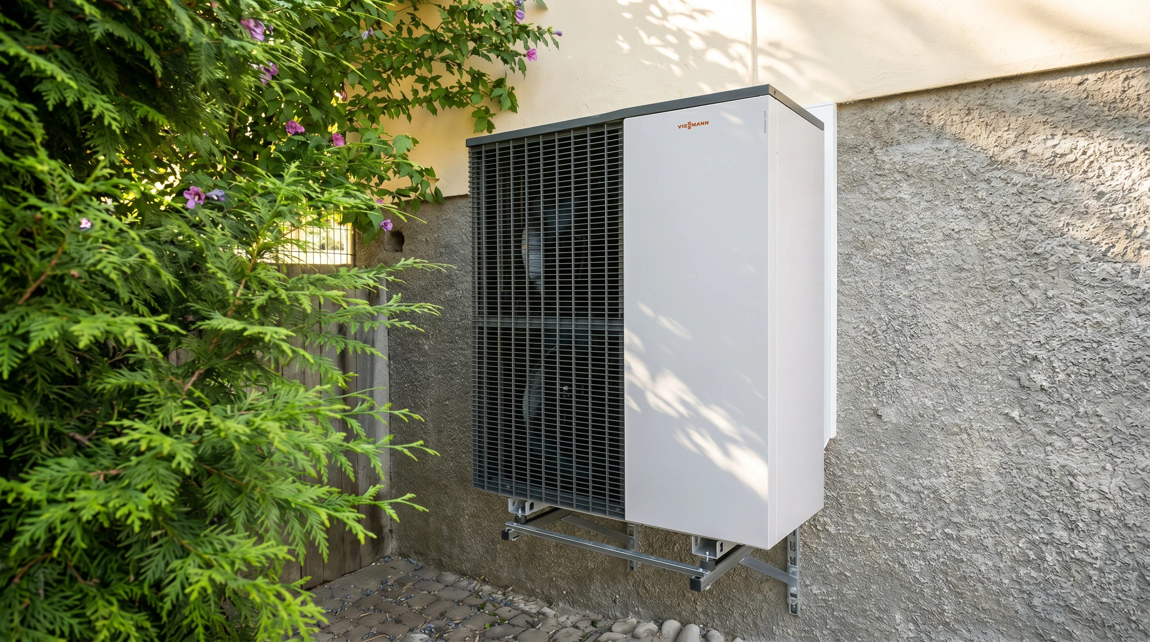 Unité extérieure de pompe à chaleur air/air **Viessmann** montée sur support mural métallique fixé à une façade en crépi blanc